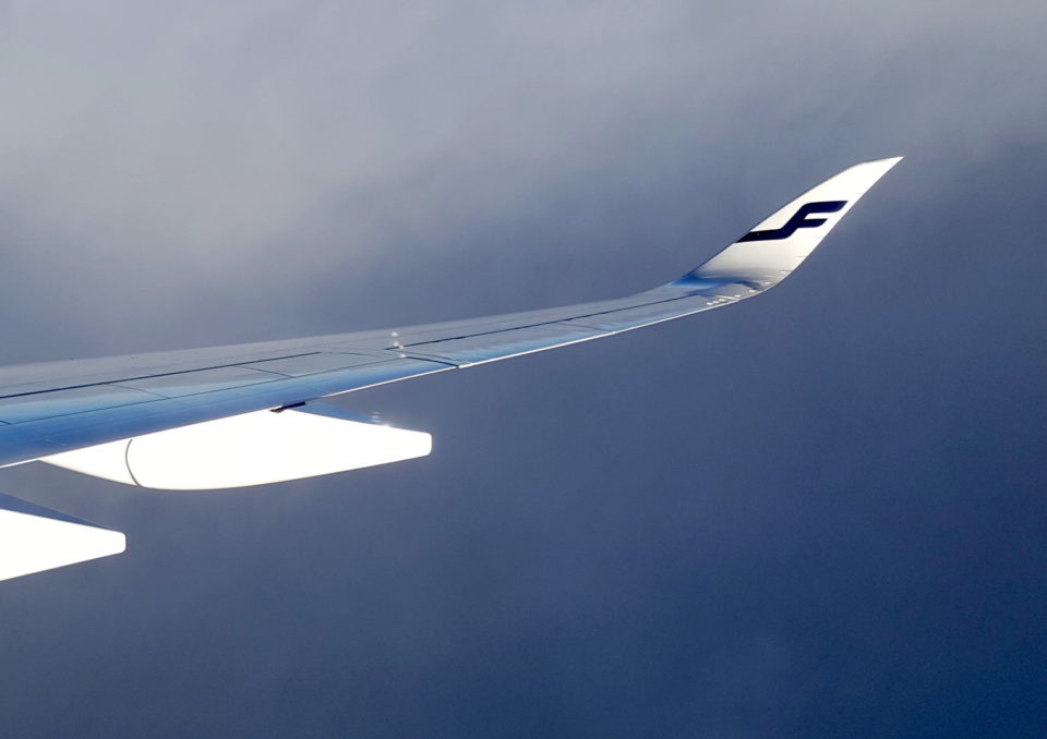 Lentokoneen siipi pilviä vasten